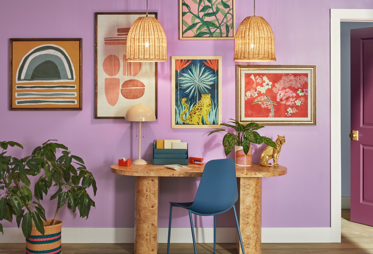 A colorful lilac wall with abstract paintings, and side table