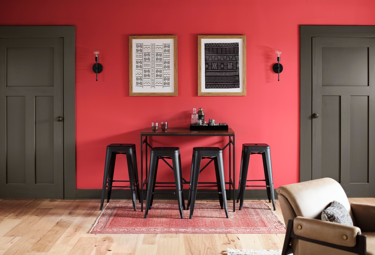 A large multipurpose room with vibrant red wall and bar table